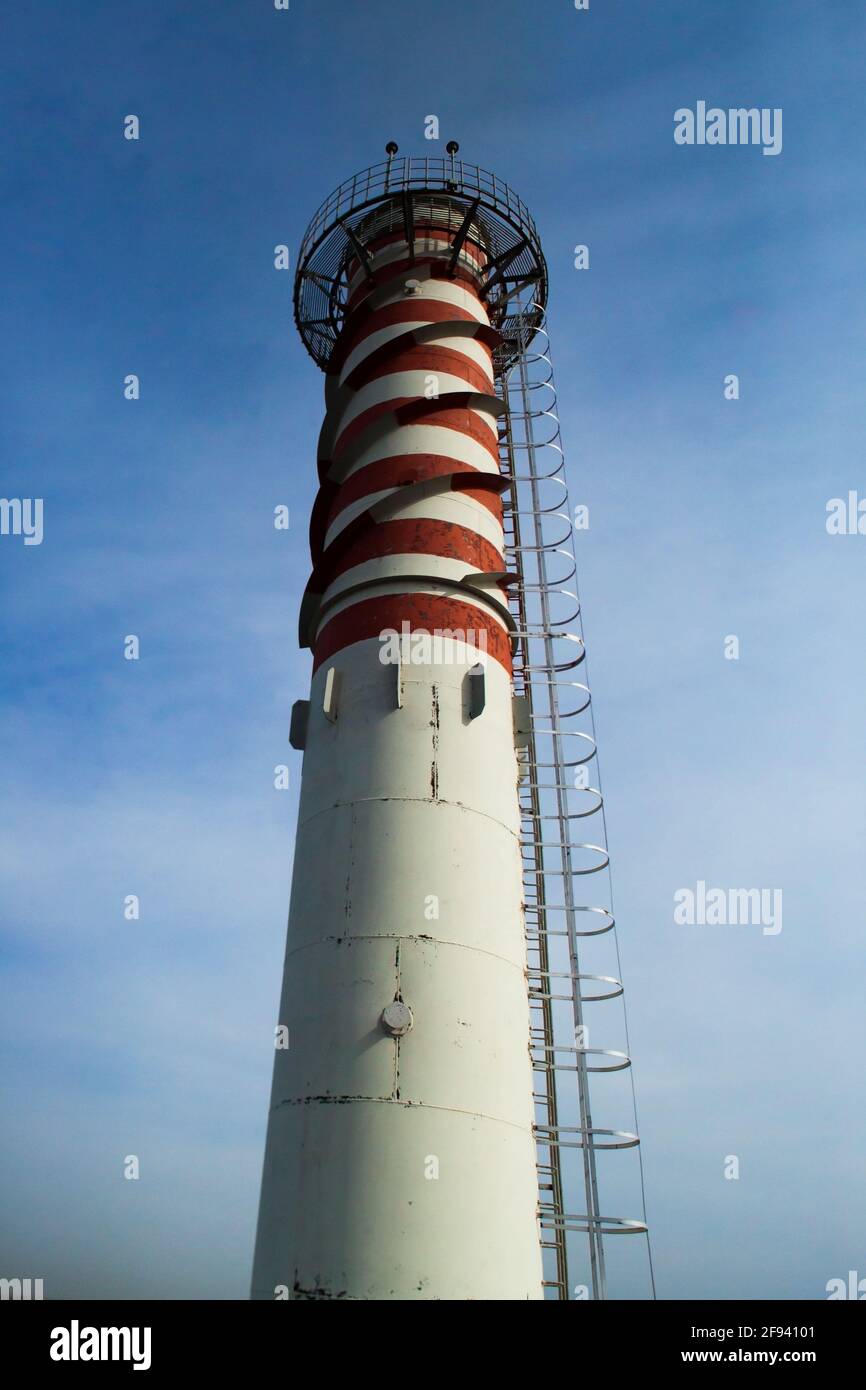 Moderna centrale a gas fumando stack su cielo blu. Strisce rosse verniciate. Luce rossa per la sicurezza degli aeromobili sulla parte superiore. Città di Uralsk, Kazakistan Foto Stock