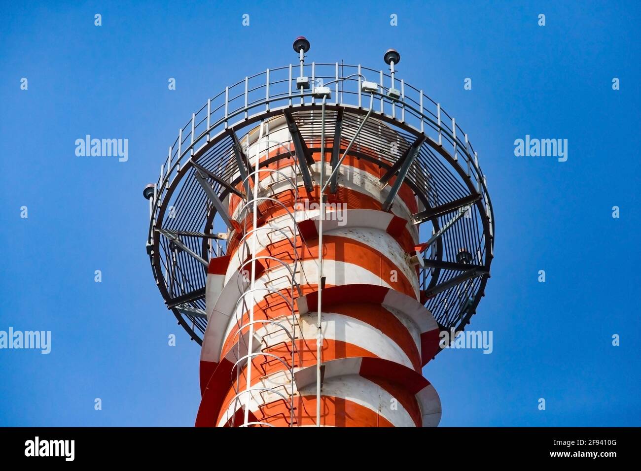 Moderna centrale a gas fumando stack su cielo blu. Strisce rosse verniciate. Luce rossa per la sicurezza degli aeromobili sulla parte superiore. Primo piano. Città di Uralsk, Kazakistan Foto Stock