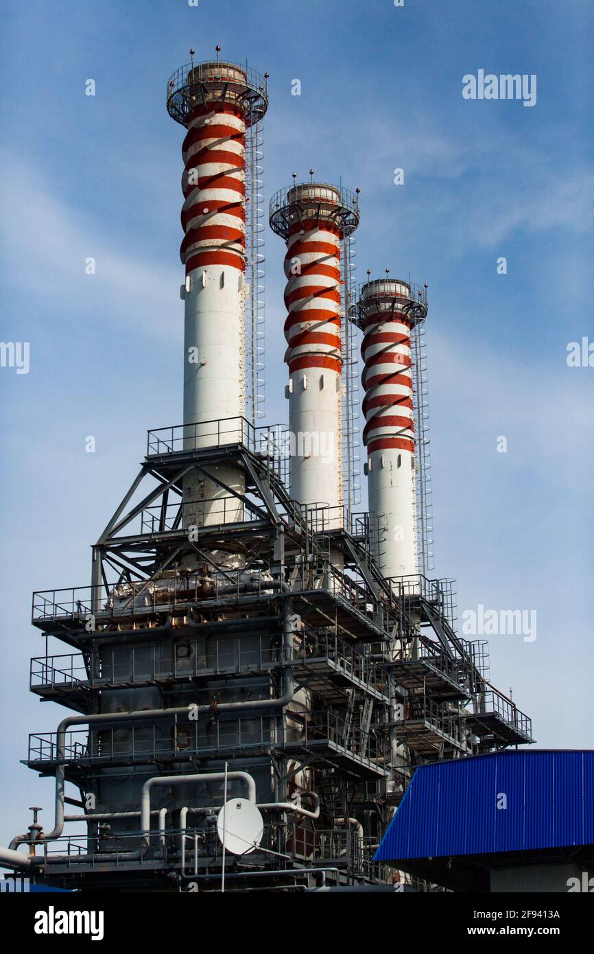 Moderna centrale a gas. Camini a strisce rosso e bianco fabbrica (pile di fumo) su sfondo blu cielo. Foto Stock