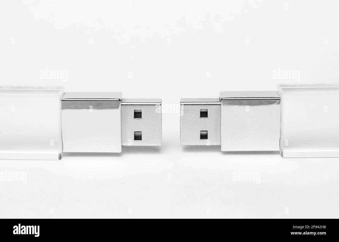 Due unità USB trasparenti in vetro con un inserto metallico su uno sfondo grigio in primo piano. Spazio di copia. Un'alta risoluzione. Foto Stock