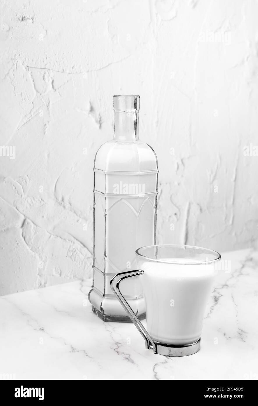 Tazza di vetro con un biberon riempito di latte. Giornata mondiale del latte. Bevande sane. Bevande rinfrescanti per l'estate. Foto Stock