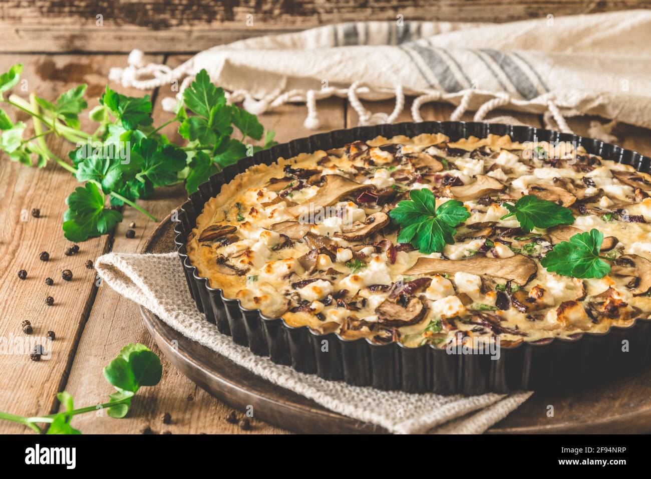 Quiche vegetariane di funghi con prezzemolo su tavola di legno Foto Stock