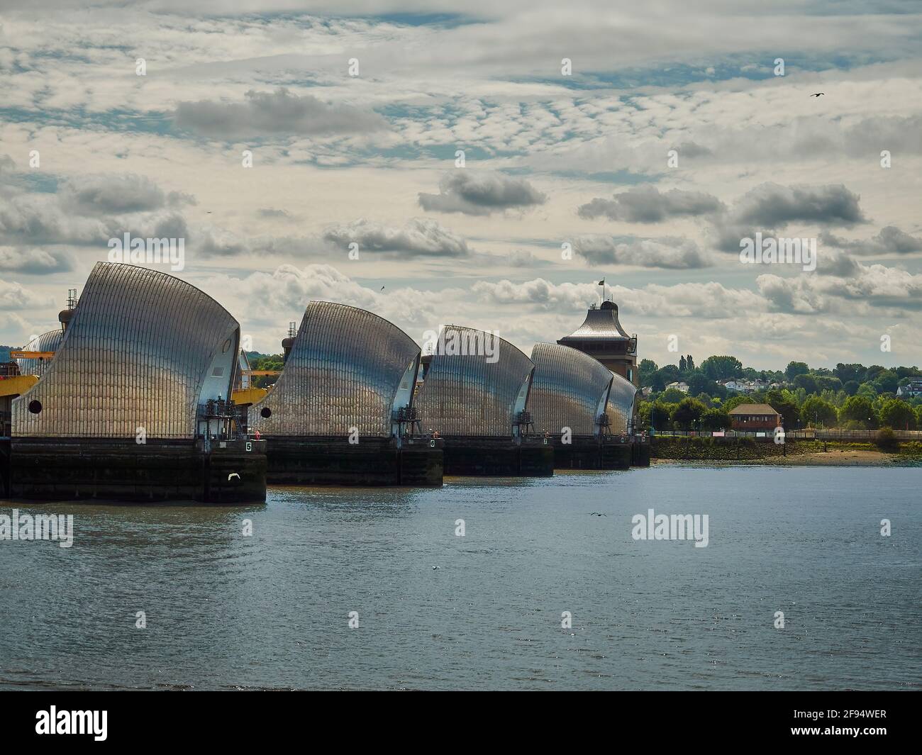 La barriera del Tamigi contro un cielo disseminato di nuvole, dalla riva nord del Tamigi. Per quanto impressionante sia, potrebbe non essere sufficiente per molto più a lungo. Foto Stock