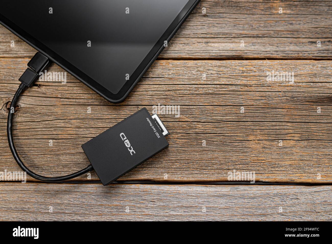 Un iPad Pro Apple con una scheda di memoria XQD collegata tramite OTG tramite un lettore di schede. Foto Stock