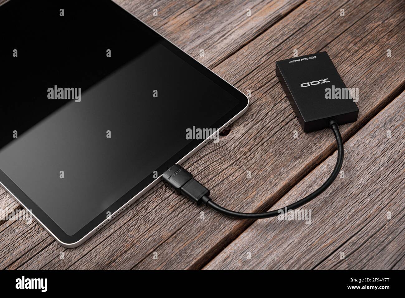 Un iPad Pro Apple con una scheda di memoria XQD collegata tramite OTG tramite un lettore di schede. Foto Stock