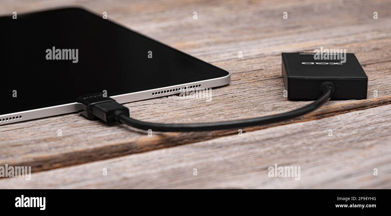 Un iPad Pro Apple con una scheda di memoria XQD collegata tramite OTG tramite un lettore di schede. Foto Stock