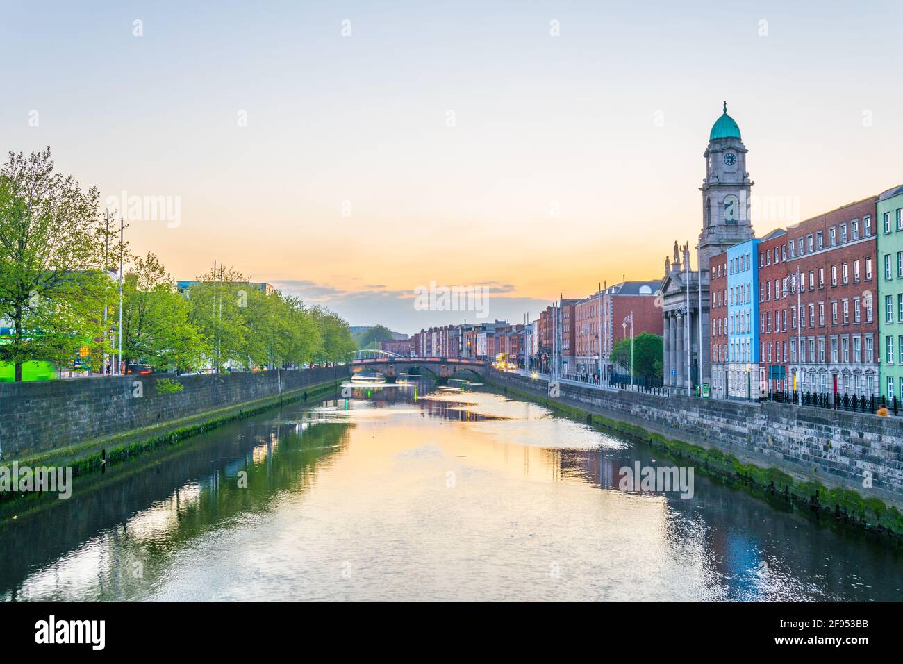 Riverside di Liffey dominato dalla chiesa di San Paolo a Dublino durante il tramonto, Irlanda Foto Stock