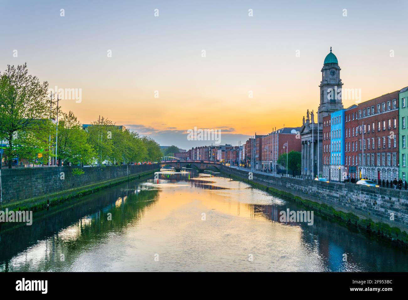 Riverside di Liffey dominato dalla chiesa di San Paolo a Dublino durante il tramonto, Irlanda Foto Stock