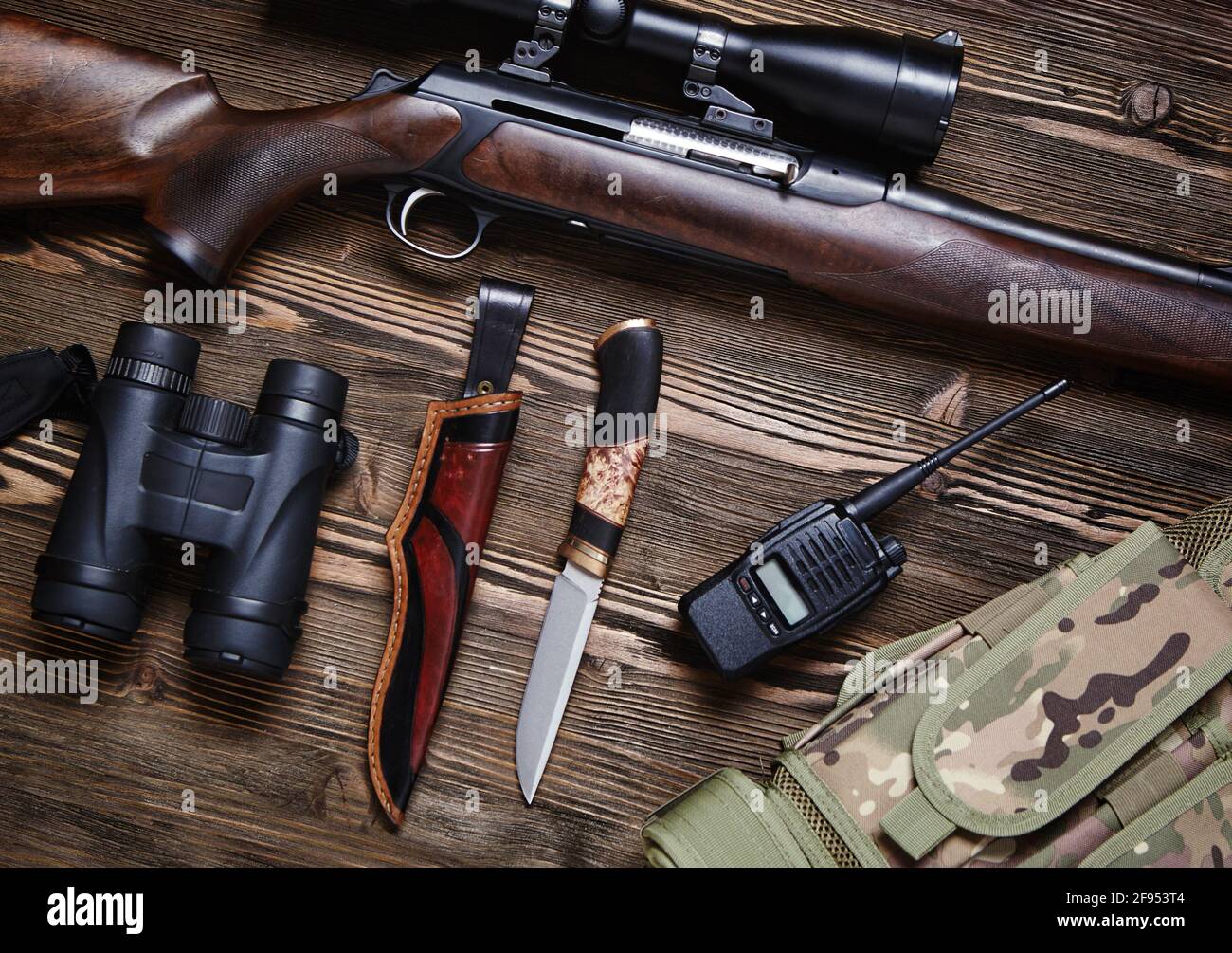 Fucile da caccia e munizioni su sfondo di legno scuro. Vista dall'alto. Foto Stock
