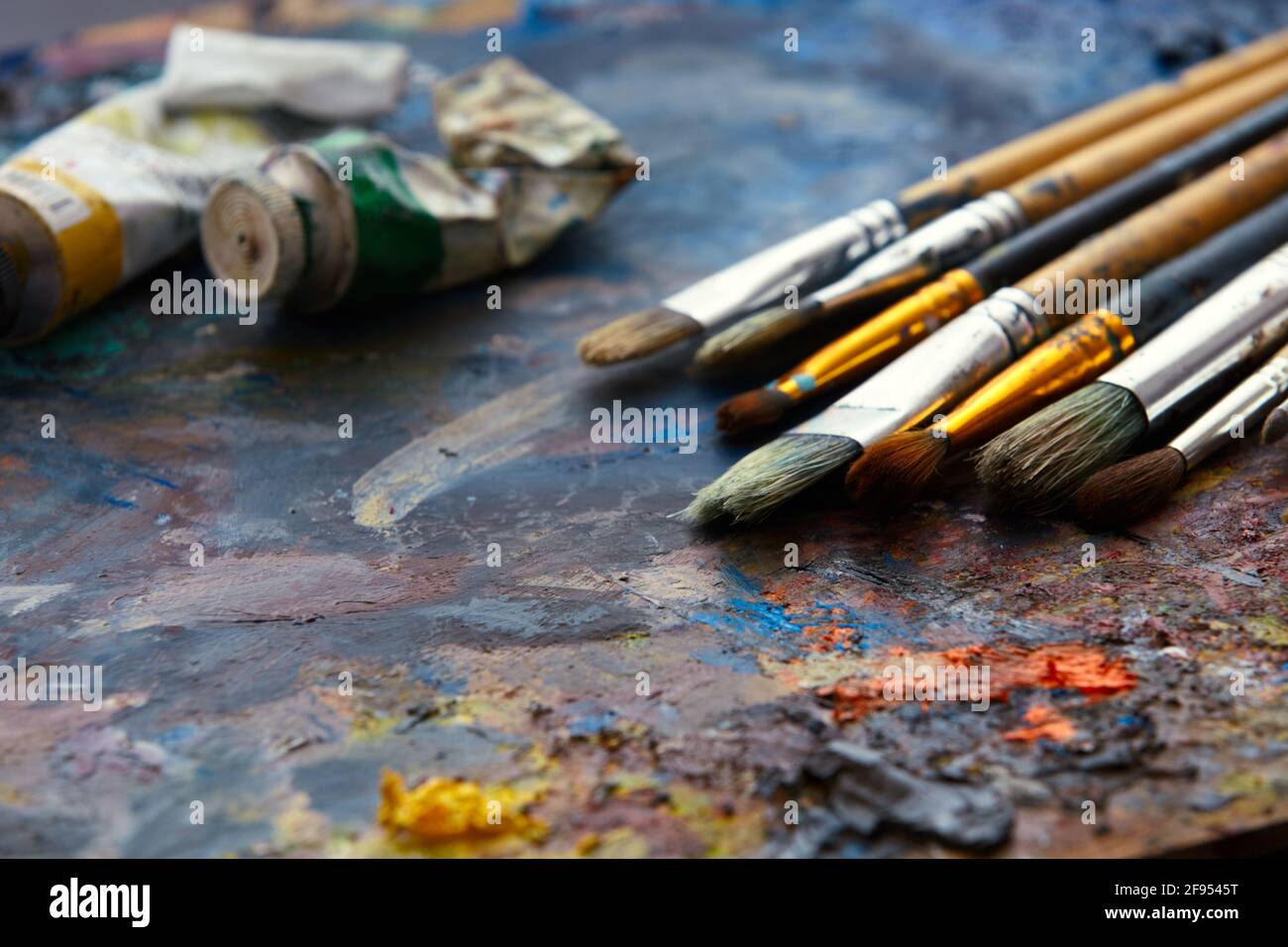 Vernici ad olio e pennelli di vernice su una tavolozza primo piano. Foto Stock