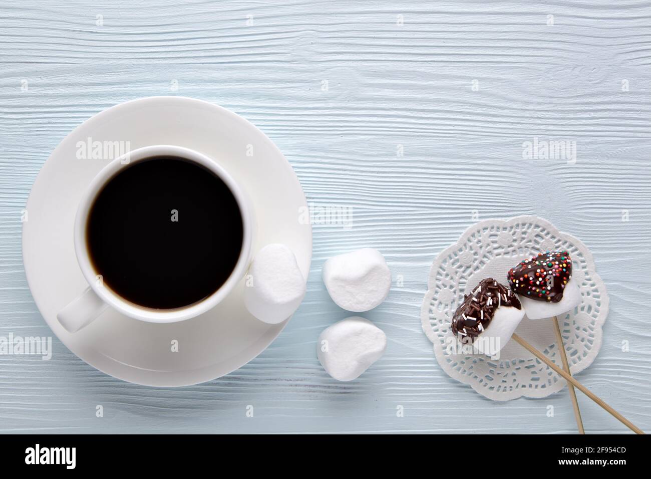 Caffè con marshmallow su uno sfondo di legno chiaro. Foto Stock