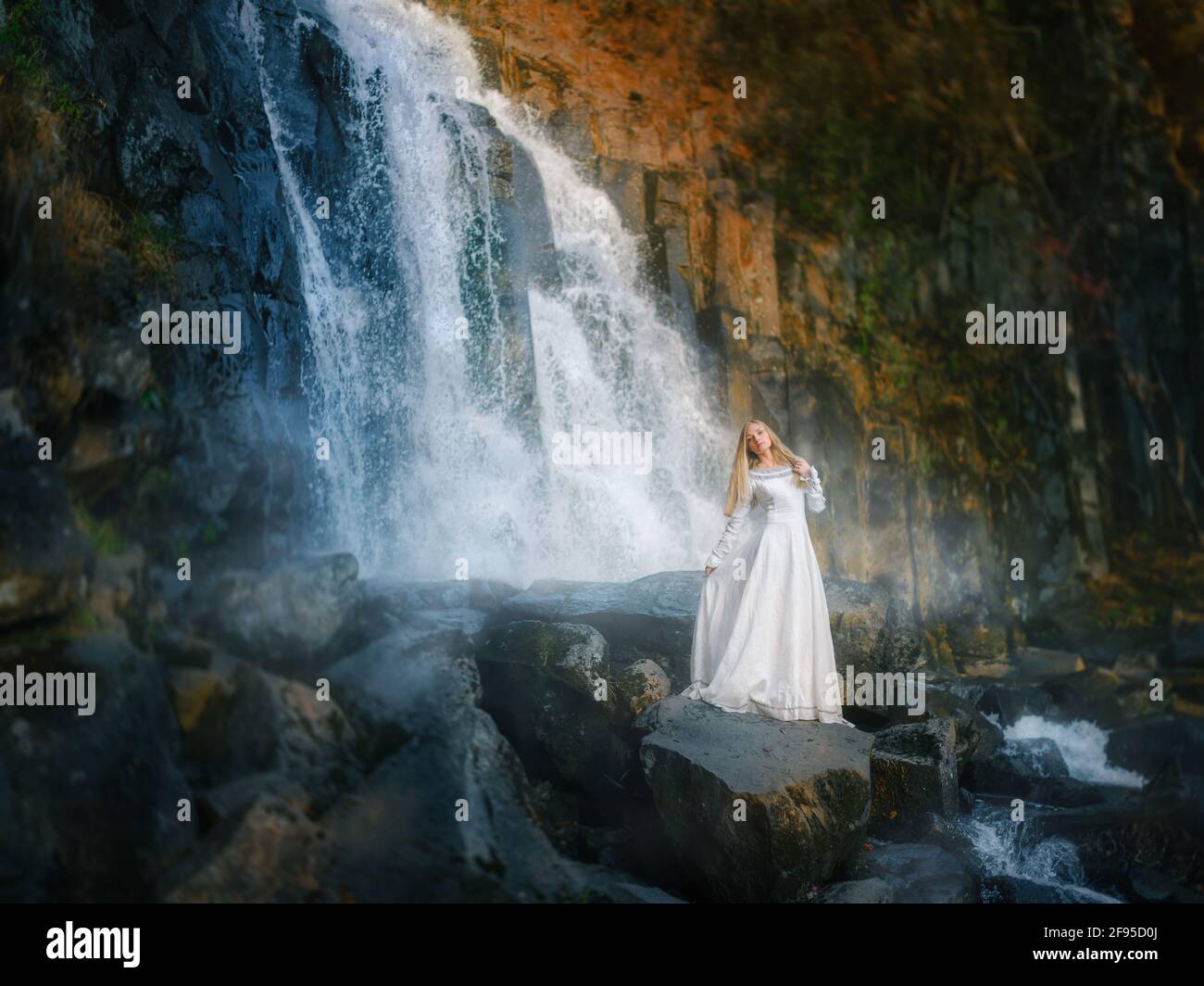 Bella giovane donna in un vestito bianco al centro di una foresta Foto Stock