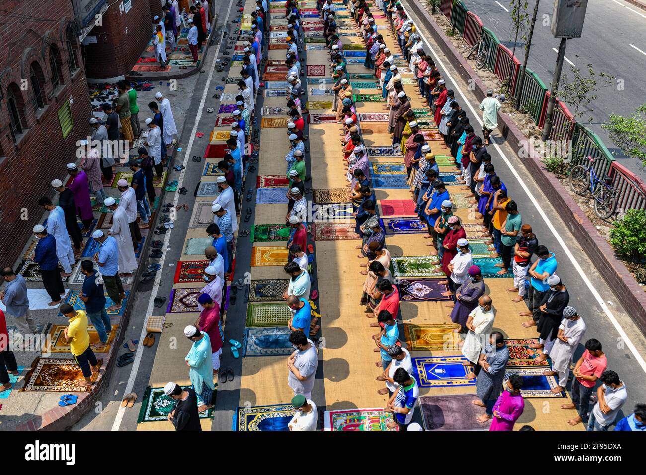 Dhaka, Bangladesh. 16 Apr 2021. I Musulmani eseguono la preghiera Jumma per strada senza mantenere alcuna distanza sociale il primo venerdì del mese santo del Ramadan, mentre le autorità del Bangladesh hanno imposto una stretta chiusura per combattere la diffusione del Covid-19 coronavirus Credit: SOPA Images Limited/Alamy Live News Foto Stock