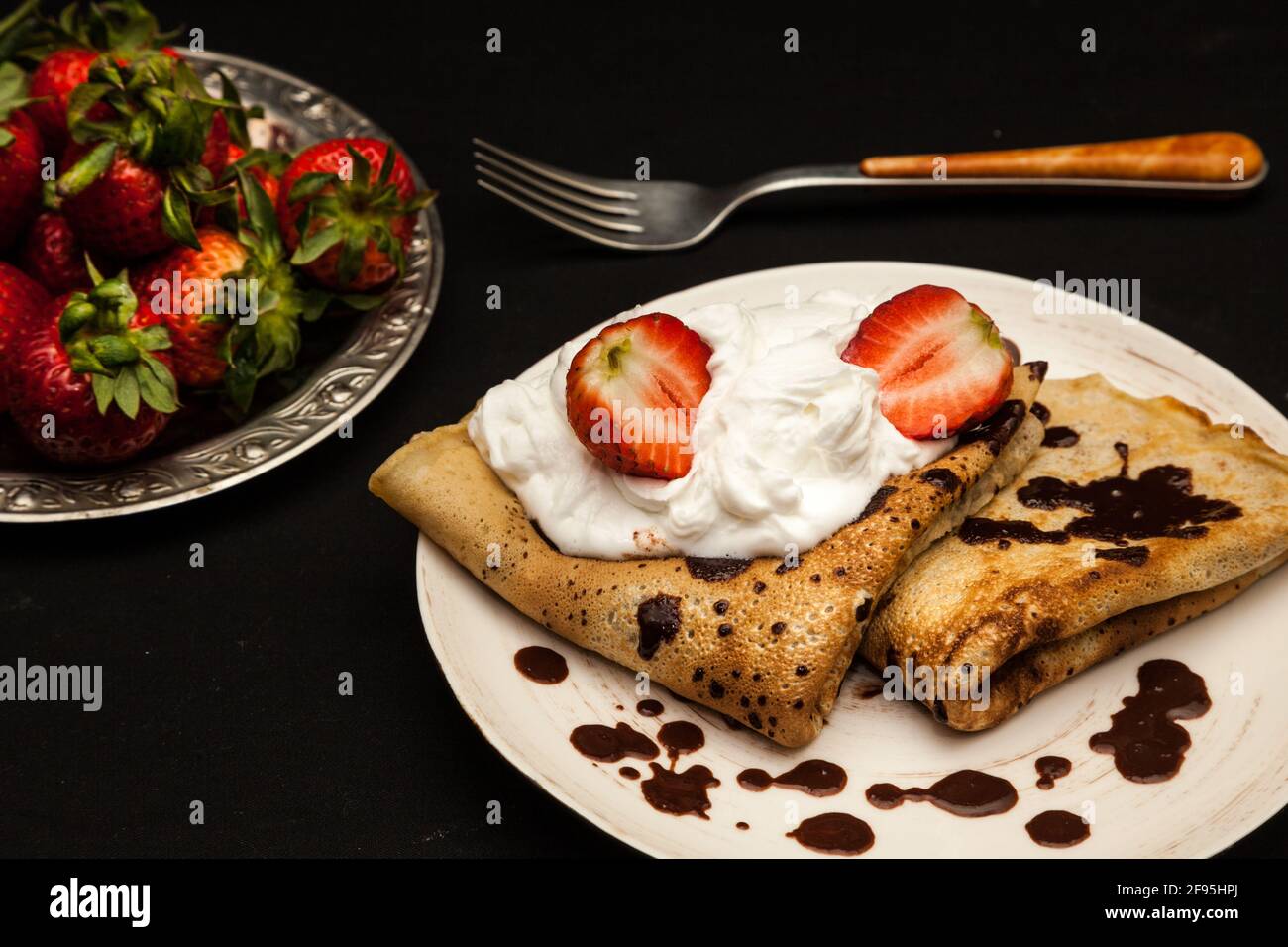 pancake con cioccolato, fragole e panna montata Foto Stock