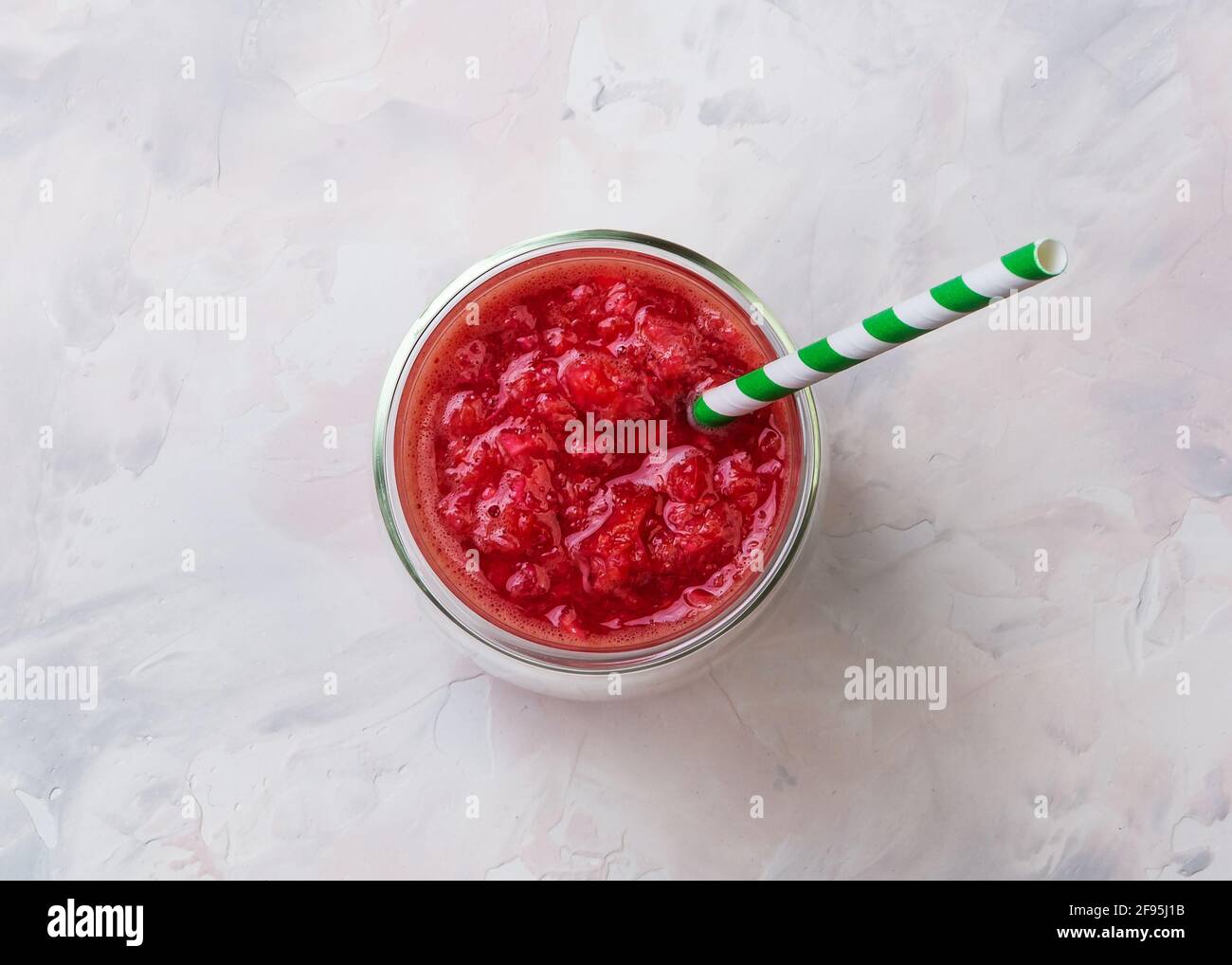 Succo d'arancia rosso in un bicchiere. Cocktail dalle arance siciliane. Idea estiva creativa minima. Foto Stock