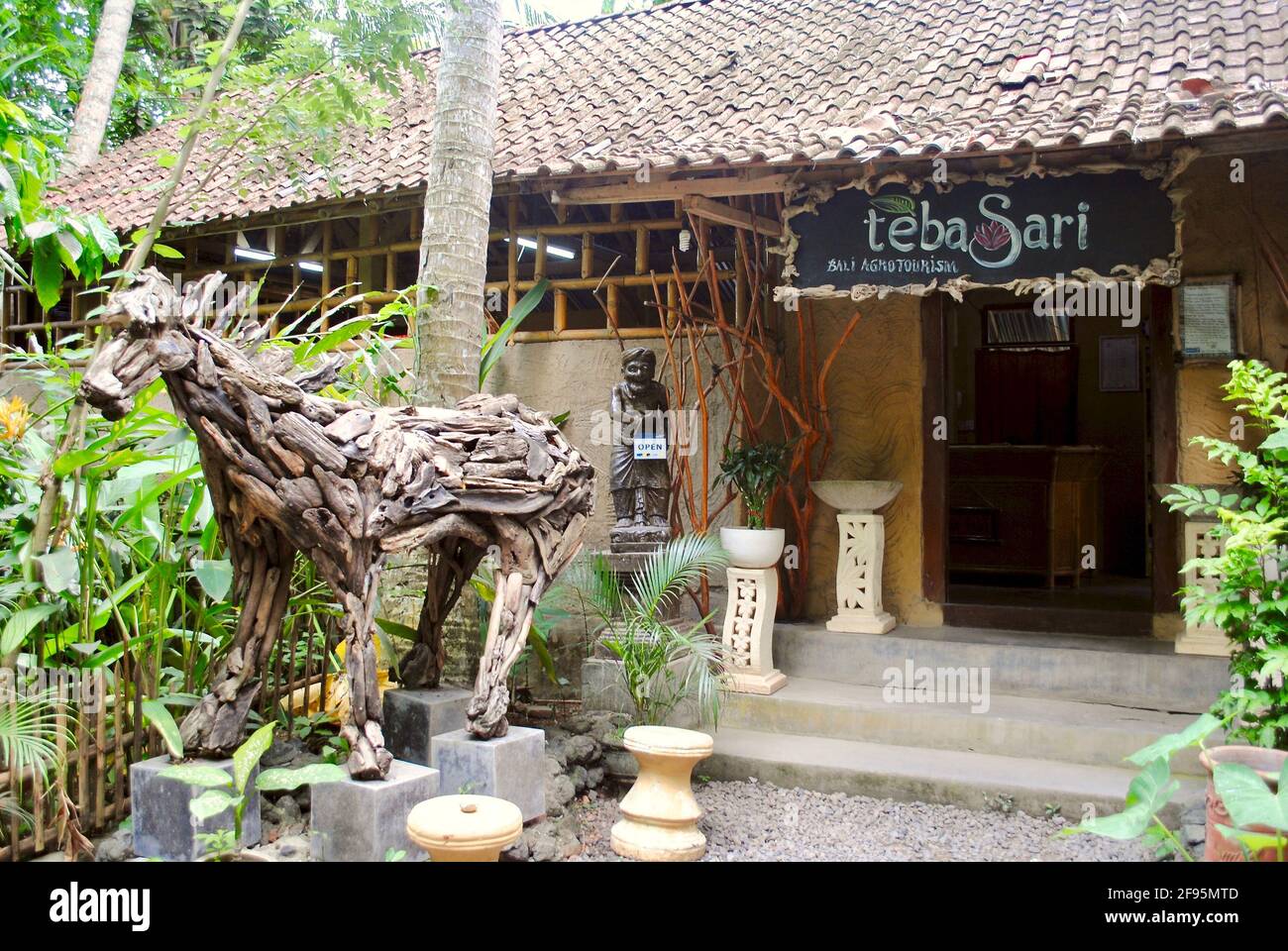 Bali, Indonesia: Ingresso al Teba Sari Agroturismo, un piccolo locale con caffè Luwak. Driftwood cavallo scultura e tetto in piastrelle. Foto Stock