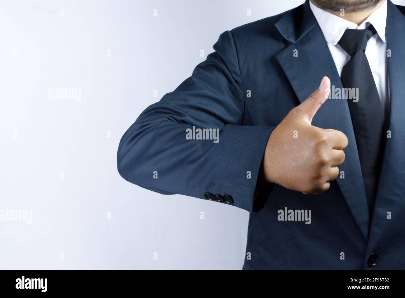 Qualcuno che gioca il ruolo di un uomo d'affari, dà un pollice in su Foto Stock