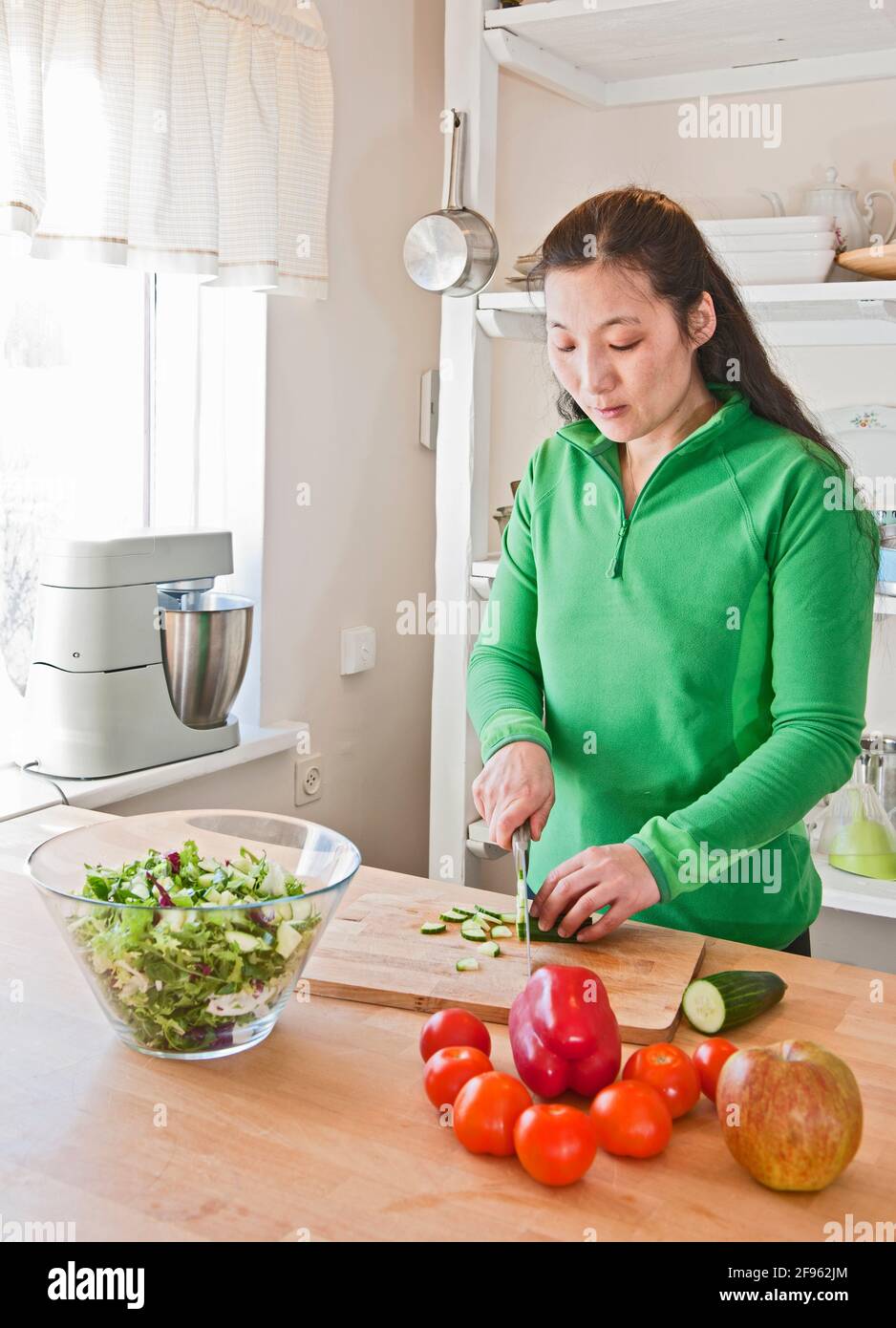 Donna che trita verdure nella cucina di una casa islandese Foto Stock