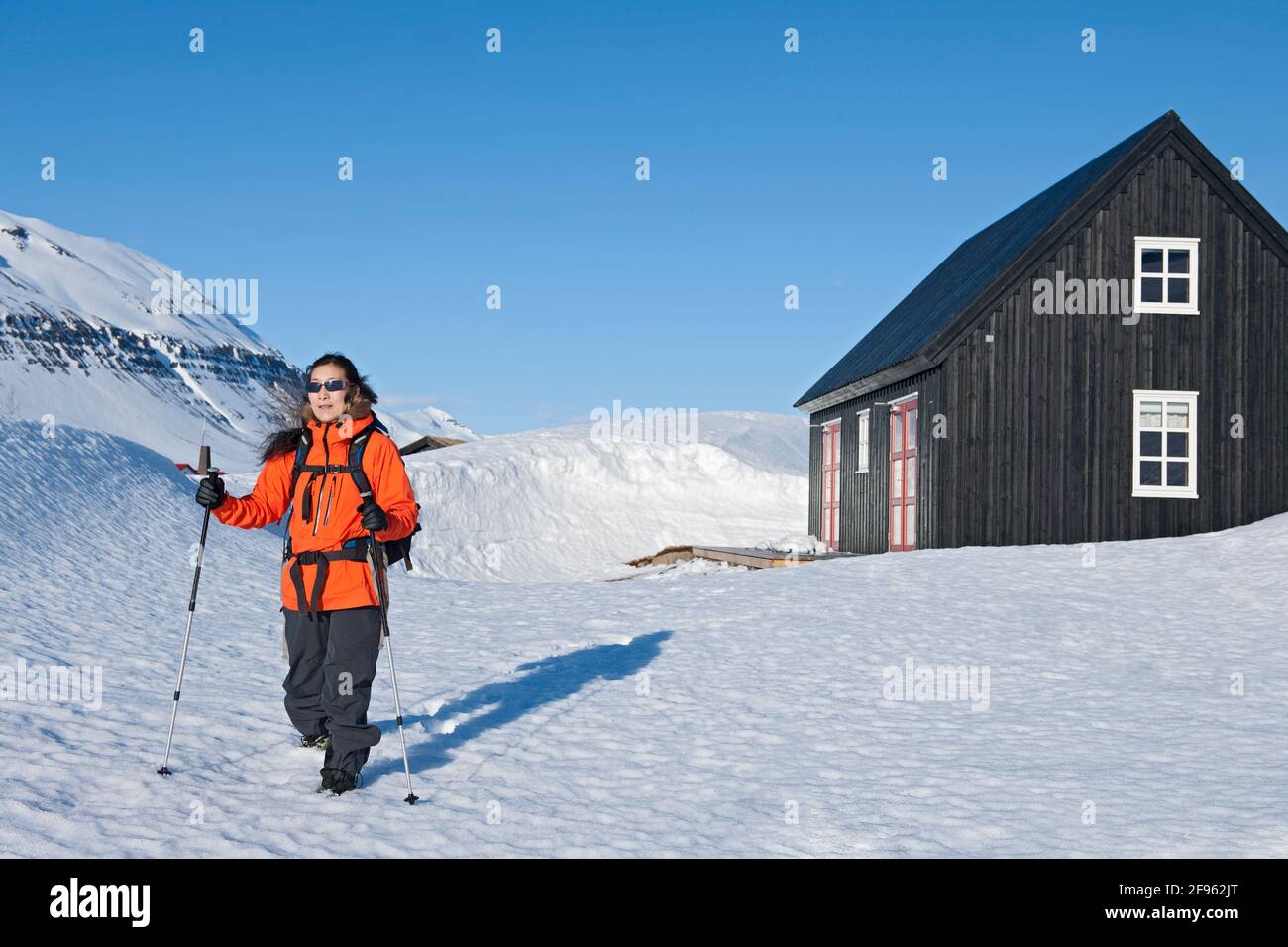 donna che parte per un'escursione dal cottage di sci in Islanda Foto Stock