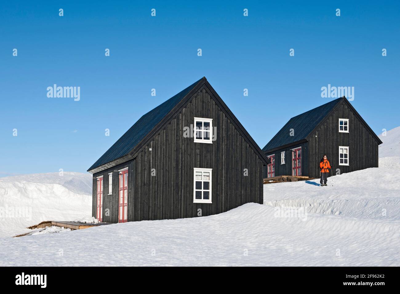 donna che parte per un'escursione dal cottage di sci in Islanda Foto Stock