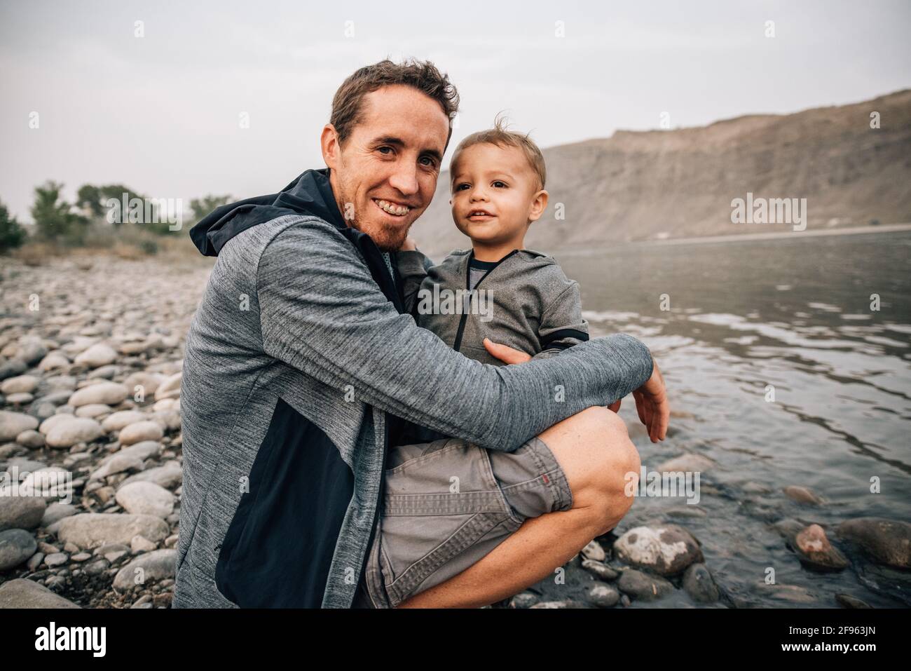 Papà e toddler abbracciano il fiume yellowstone su una natura camminare Foto Stock
