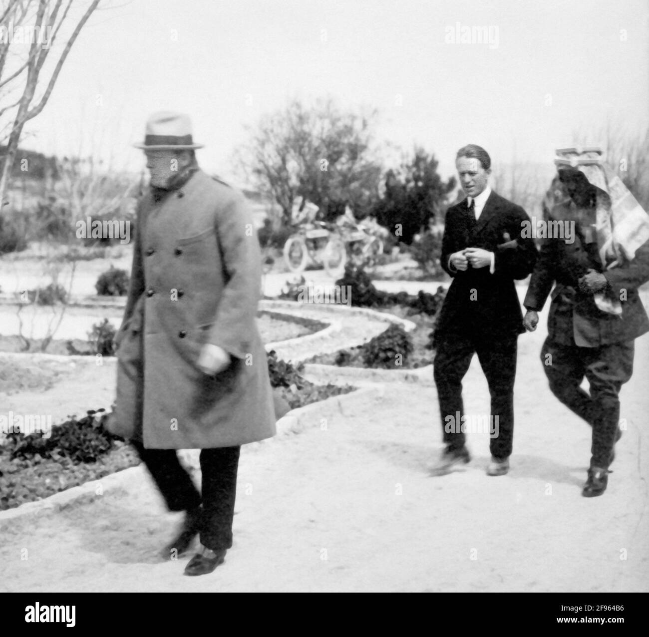 Winston Churchill e T. E. Lawrence (Lawrence d'Arabia) camminando con Emir Abdullah nel giardino della Casa del Governo, Gerusalemme, durante la Conferenza del Cairo del 1921 Foto Stock