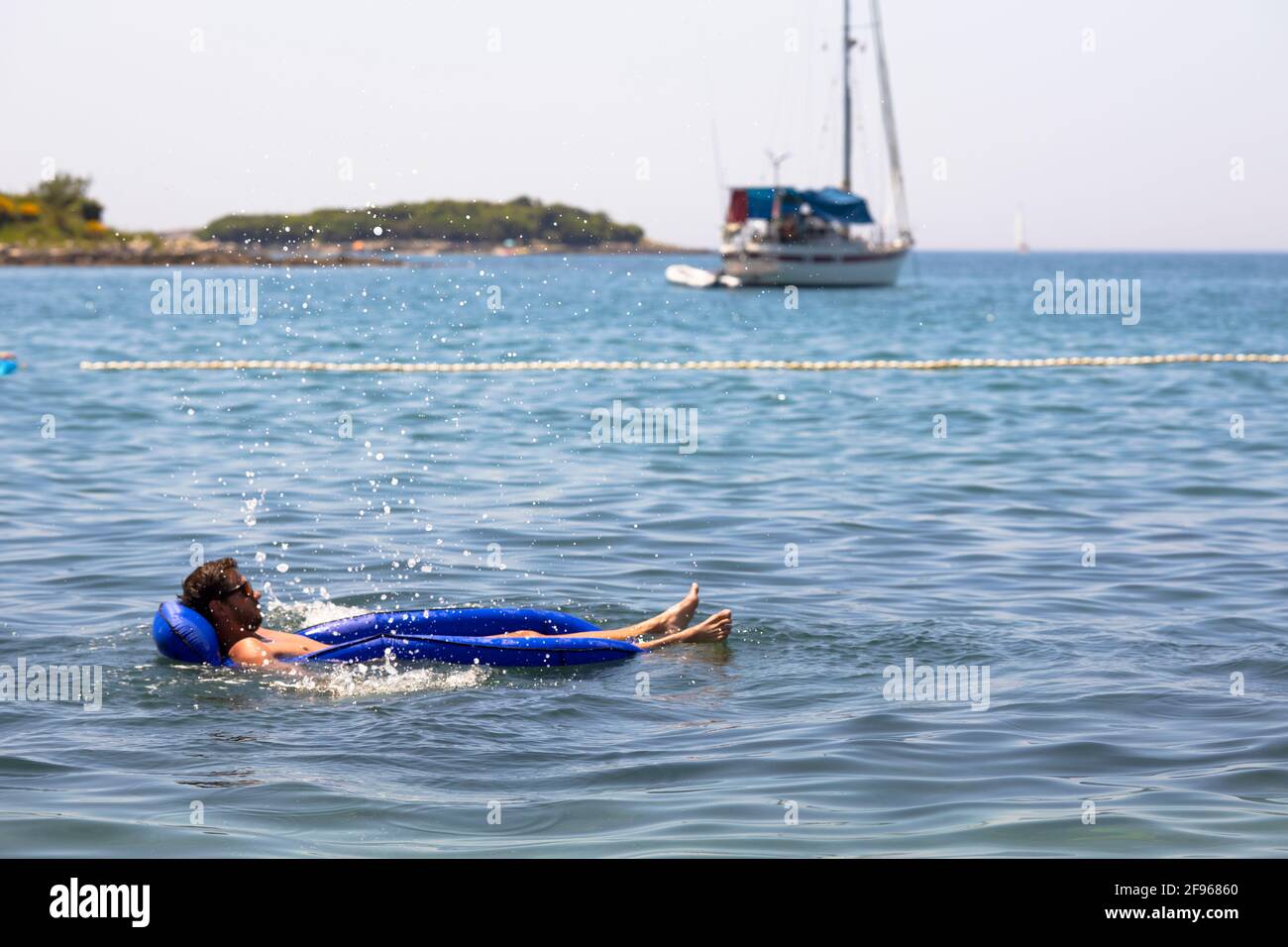 Vacanzieri in acqua di fronte alla barca a vela. Croazia. Foto Stock