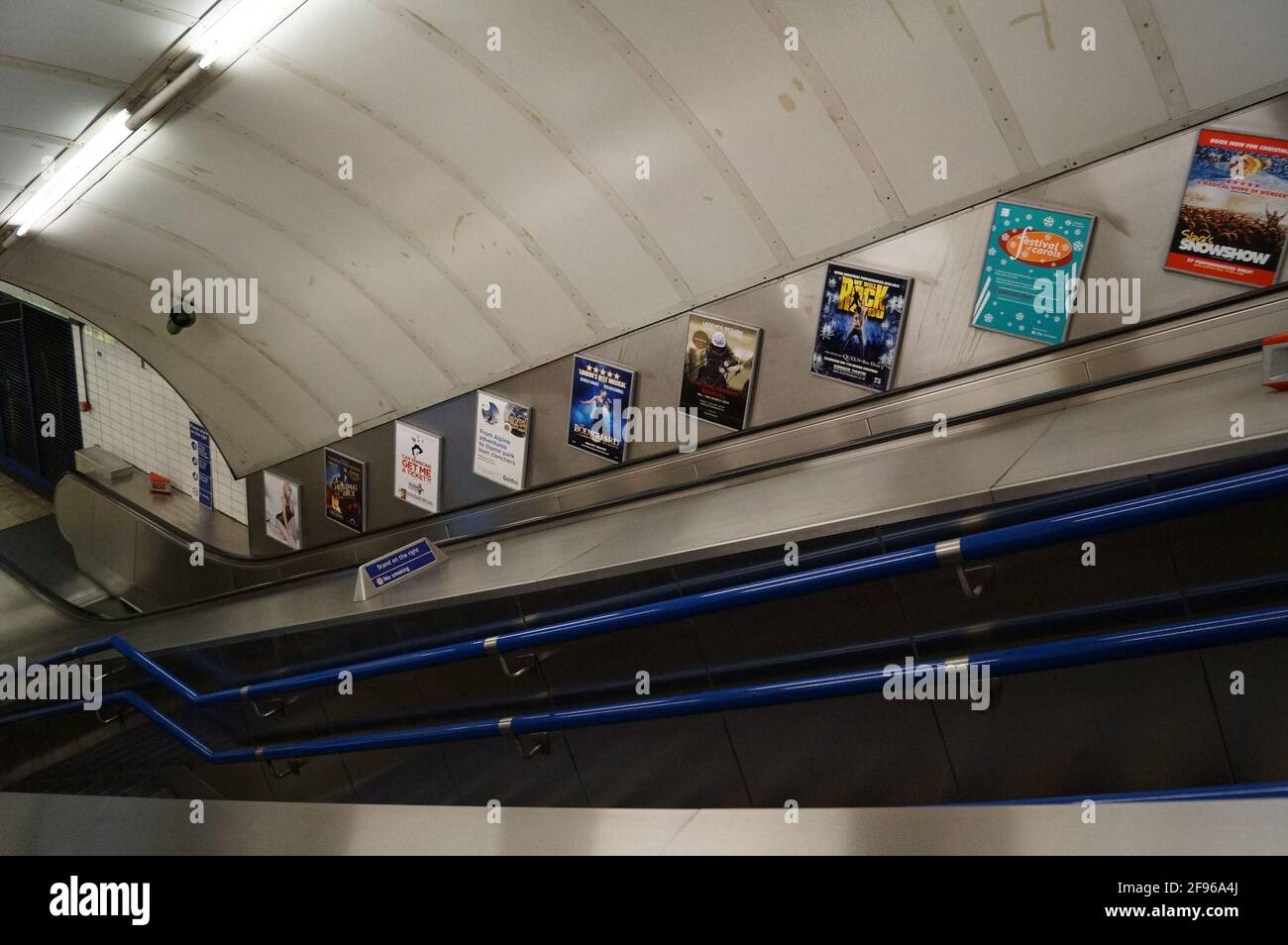 Londra, Regno Unito: scale e scale mobili per i binari alla stazione della metropolitana Whitechapel, sulla District Line Foto Stock