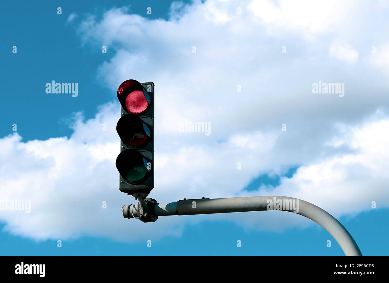 Semaforo rosso in strada contro il cielo blu con bianco cloud Foto Stock
