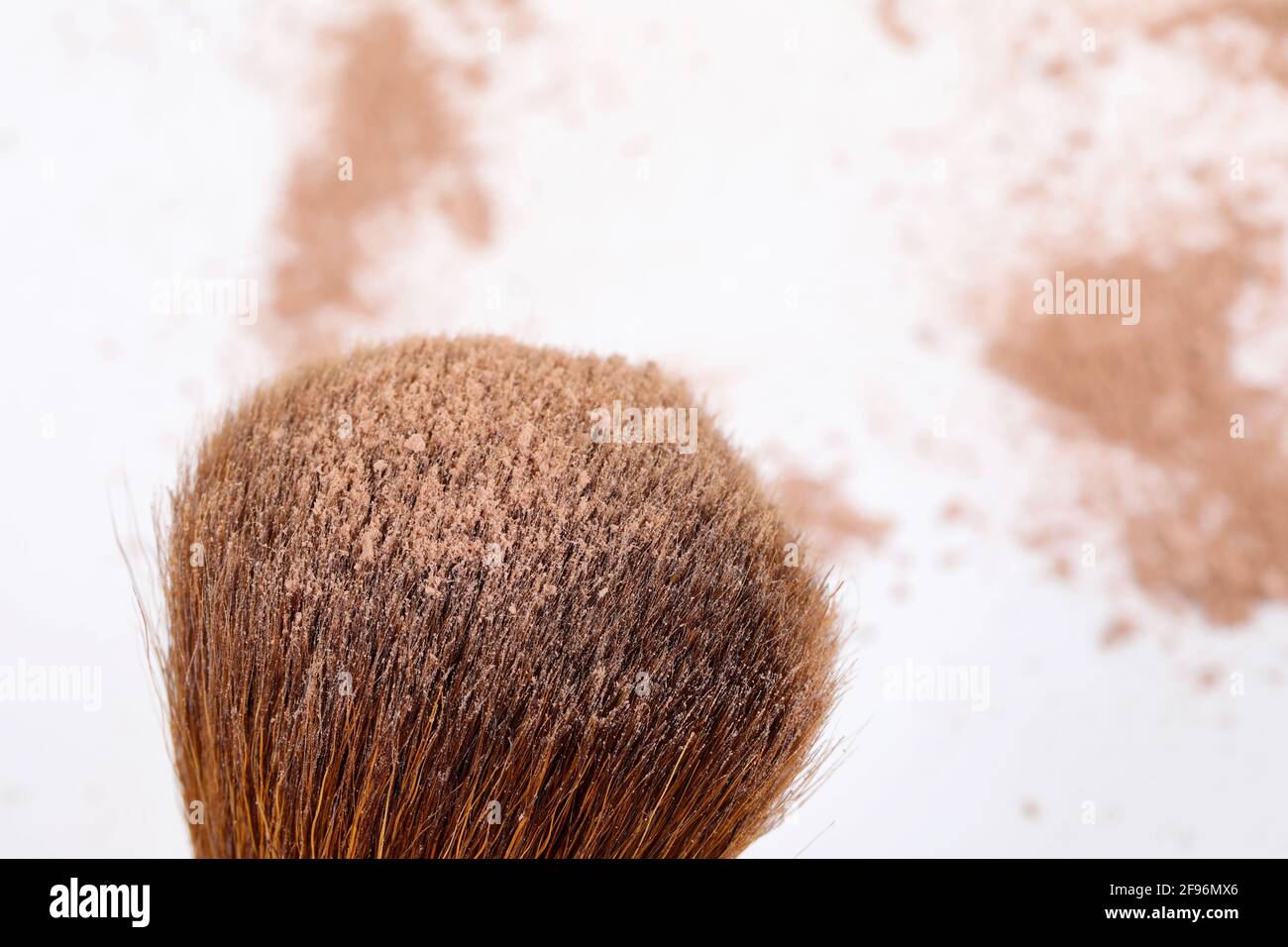 Polvere sfoltata e spazzola di trucco del viso di colore marrone scuro, isolata su sfondo bianco. Foto Stock