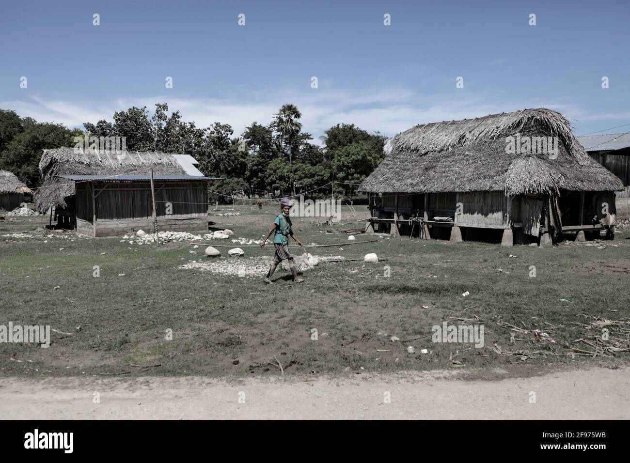 Una donna che cammina intorno alle case colpite da inondazioni durante le inondazioni di flash e frane che ha colpito diverse aree a Nusa Tenggara Est. Secondo i dati della National Disaster Management Agency (BNPB), il numero di decessi dovuti alle inondazioni scatenate da Seroja Tropical Cyclone che si sono verificate il 4 aprile 2021 ha raggiunto 181 persone. Foto Stock