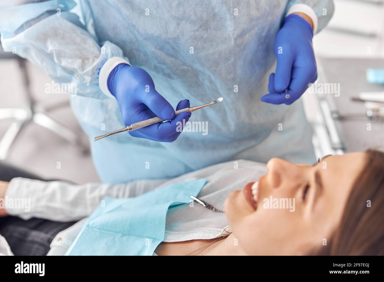 Ritratto di giovane dentista in guanti che esamina i denti di femmina cliente in ospedale Foto Stock