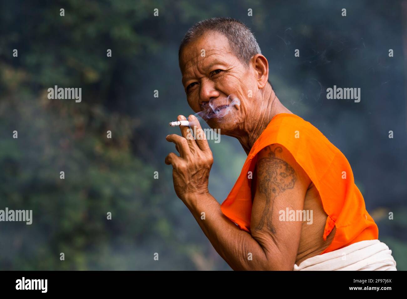 Laos, Luang Prabang, il tempio Vat Xieng Mene Saiyasettharam, monaco, fumo, Foto Stock