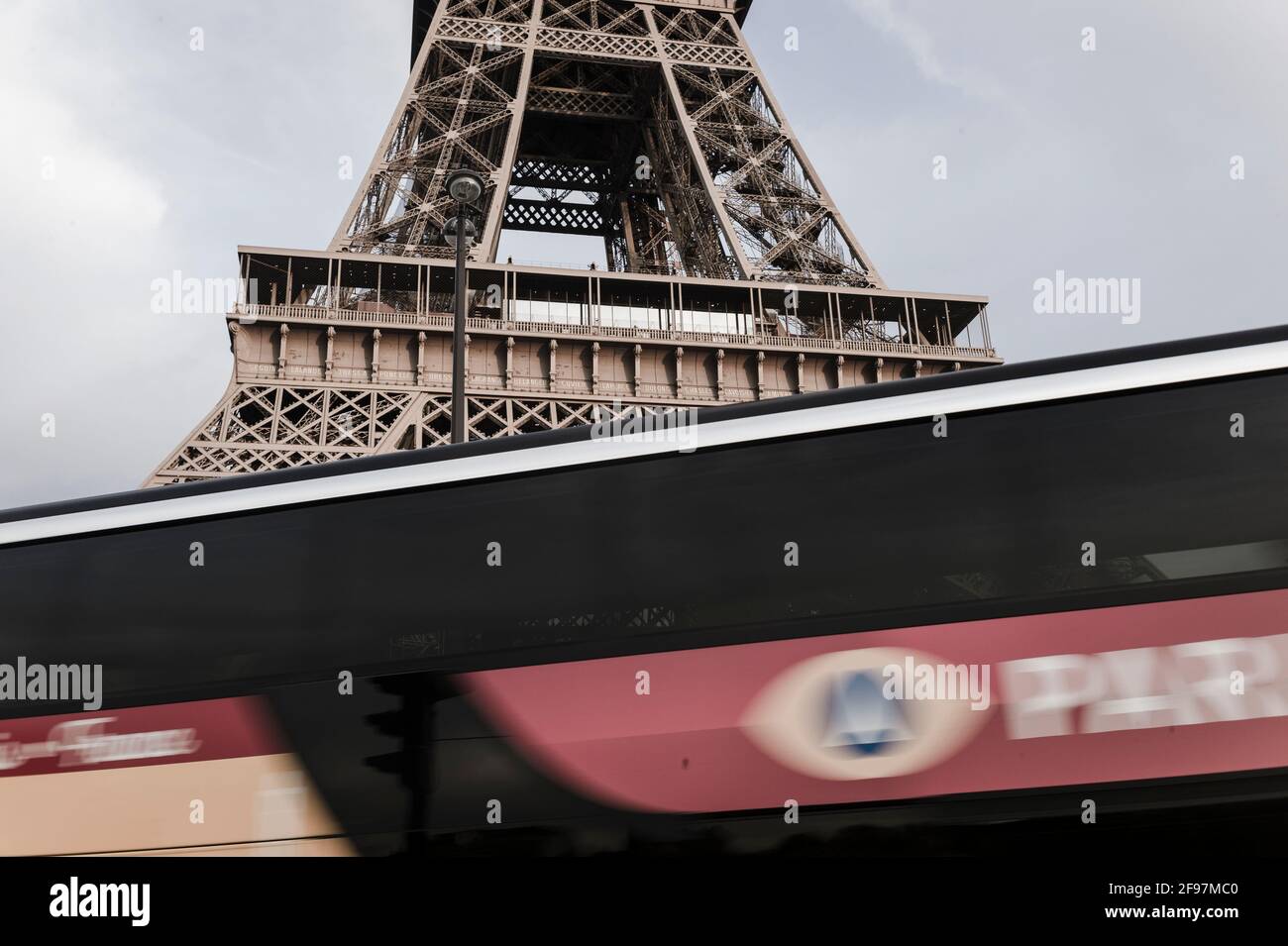 Torre Eiffel (tour Eiffel) a Parigi, Francia - nascosta dietro un pullman che viaggia. La Torre Eiffel è il monumento a pagamento più visitato al mondo; 6.91 milioni di persone la salirono nel 2015. Foto Stock