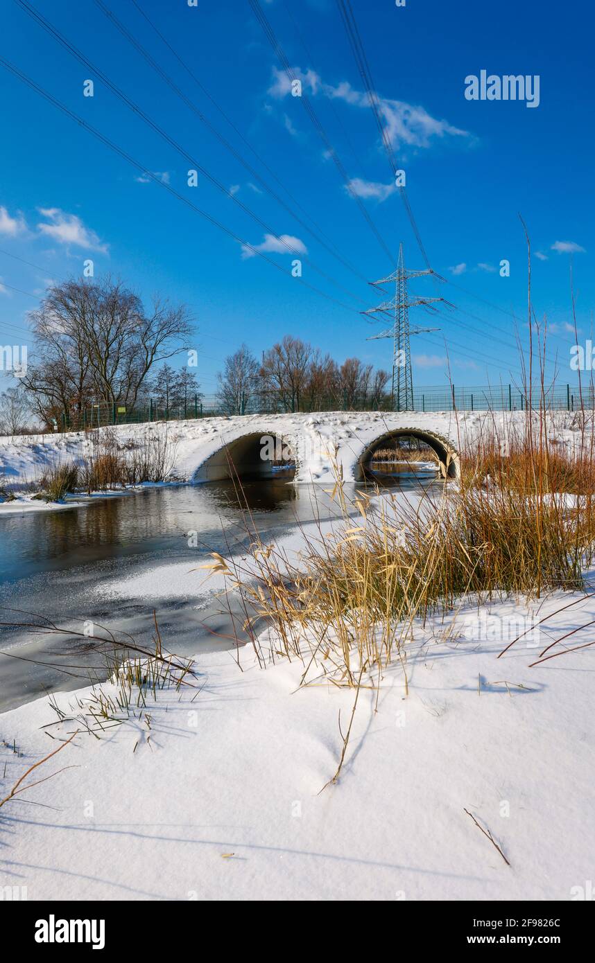 Bottrop, Renania Settentrionale-Vestfalia, Germania - paesaggio invernale soleggiato nella zona della Ruhr, ghiaccio e neve sulla rinomata Boye, il piccolo fiume viene rinaturato, viene trasformato in un corpo naturale di acqua, il Boye fa parte del sistema fluviale Emscher e quindi fa parte della conversione Emscher, in precedenza era una fogna di acque reflue, acque reflue, acque reflue miste con acque di superficie e acque reflue. Foto Stock