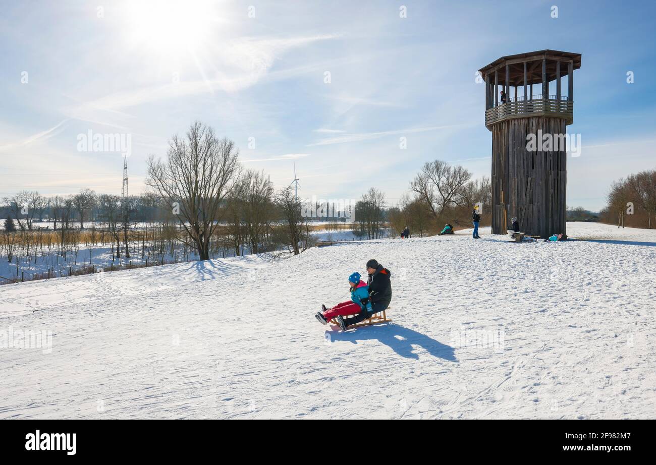 Recklinghausen, Renania Settentrionale-Vestfalia, Germania - Sunny paesaggio invernale nella zona della Ruhr, Emscherkunst nella neve, Torre Kawamata sull'Emscher, PASSERELLA E TORRE, 2010, by Tadashi Kawamata, le famiglie vanno in slitta Foto Stock