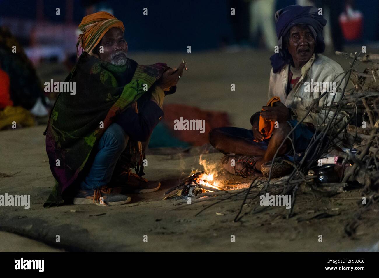 India, Varanasi, scene ad Asi Ghat, mendicanti, fuoco, sera Foto Stock