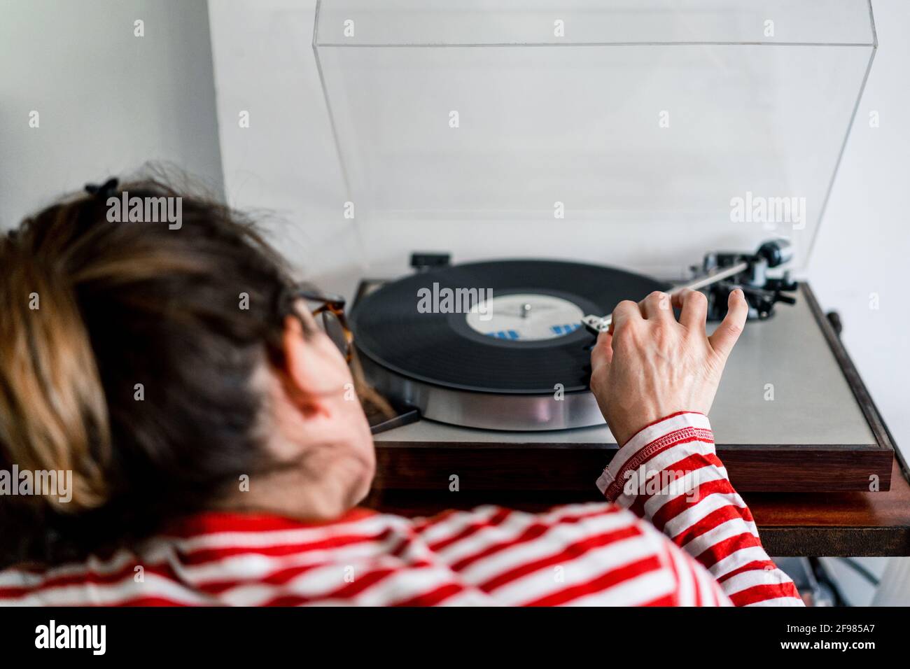 Da donna sopra che mette un compact disc in uno stereo Foto Stock