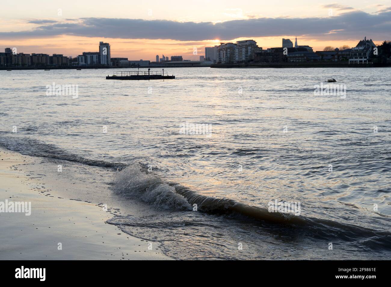 Una grande onda ha lavato la spiaggia nel fiume Tamigi a Greenwich Cutty Sark, Londra, tramonto, il sole scoppiò Foto Stock