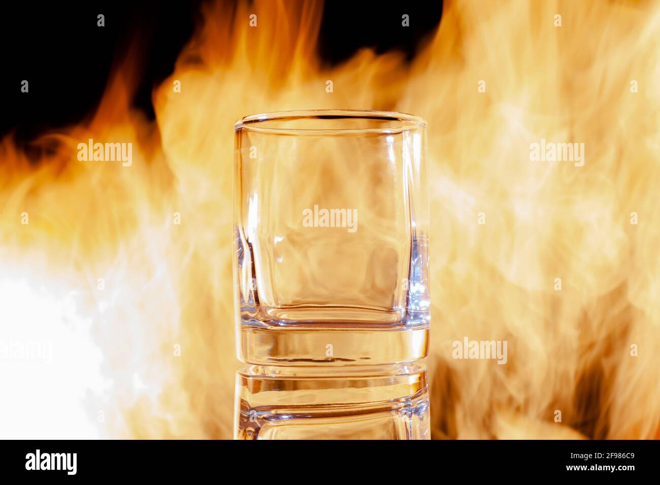 un bicchiere di brandy vuoto sullo sfondo del fuoco, posizionarlo sotto il testo Foto Stock