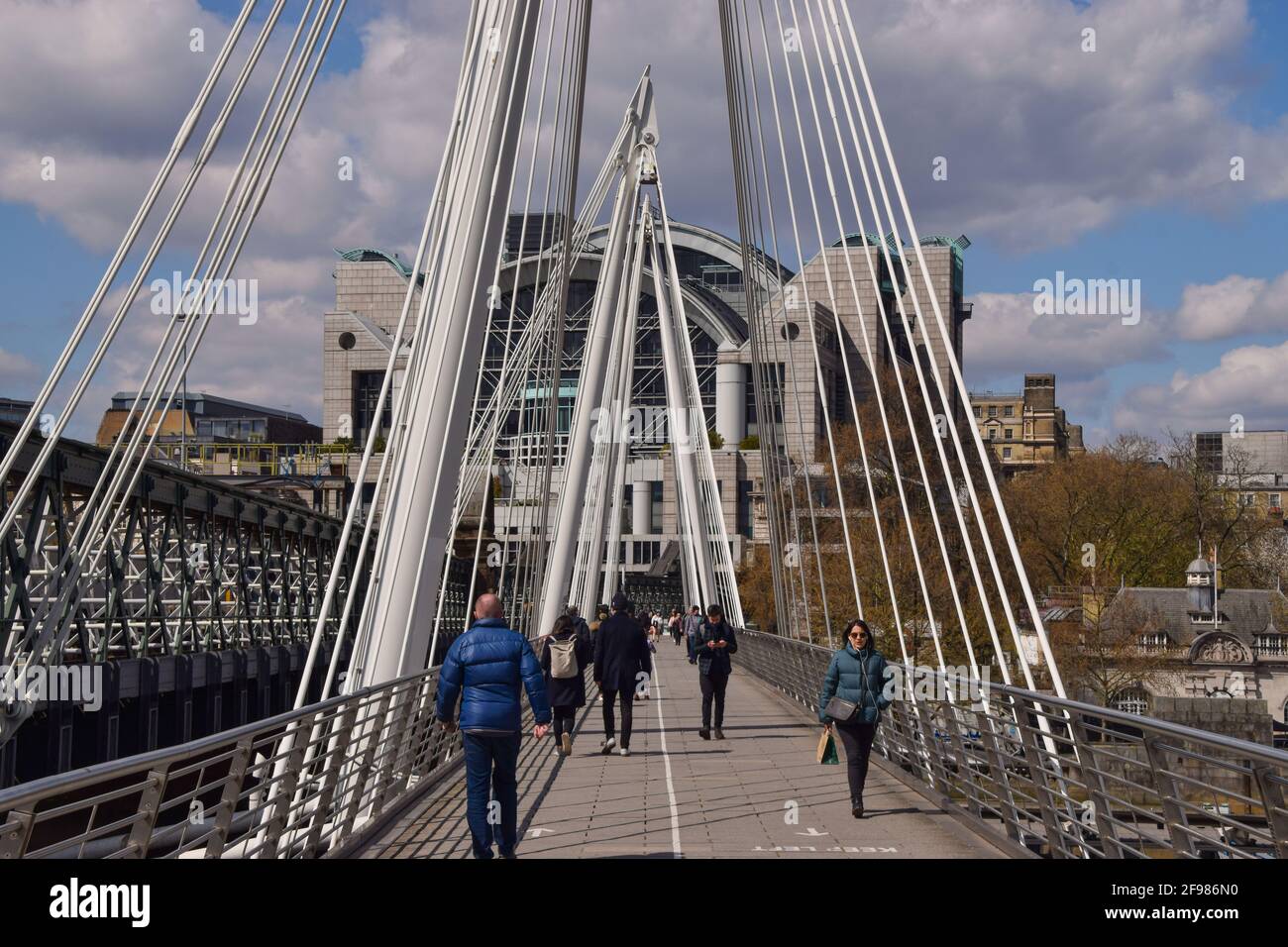 Londra, Regno Unito. 16 Apr 2021. La gente cammina lungo il Golden Jubilee Bridge. Le regole di Lockdown sono state rilassate in Inghilterra all'inizio di questa settimana. Credit: Vuk Valcic/Alamy Live News Foto Stock