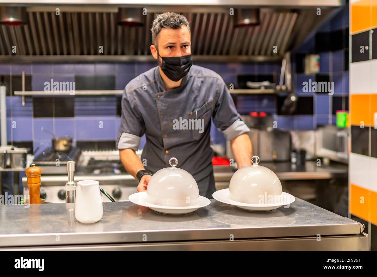 il favoloso chef cuoca con i suoi piatti a base di carne affumicata pronti a servire Foto Stock