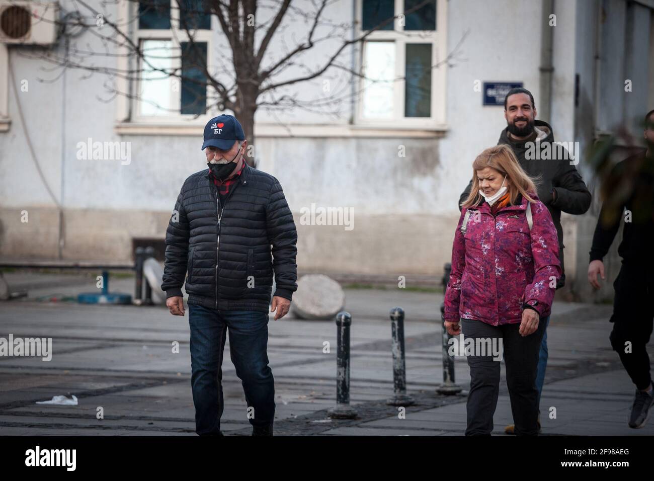 BELGRADO, SERBIA - 21 FEBBRAIO 2021: Anziano che indossa una maschera respiratoria sotto il naso che cammina in una strada di Belgrado, durante la corona Foto Stock