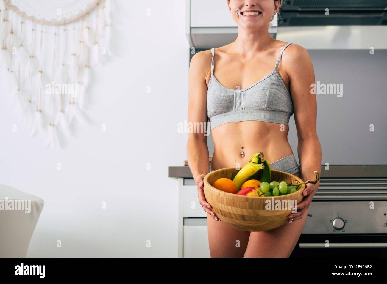 Fitness e dieta femminile perfetto corpo giovane ragazza tenendo cestello pieno di frutta fresca e vitamina - concetto di felice persone e stile di vita sano nutrizione alimentare per l'abs muscolare Foto Stock