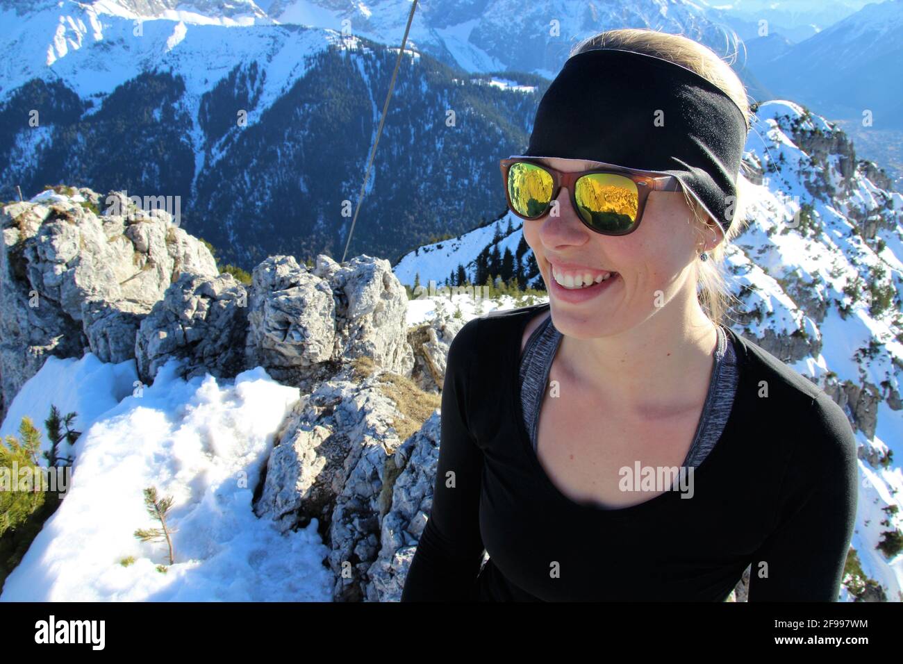 Giovane donna è felice della grande vista, escursione invernale al Signalkopf (1895 metri) sullo sfondo il Wörner, Tiefkarspitze e i Monti Karwendel, Europa, Germania, Baviera, alta Baviera, Isar Valley, Krün Foto Stock