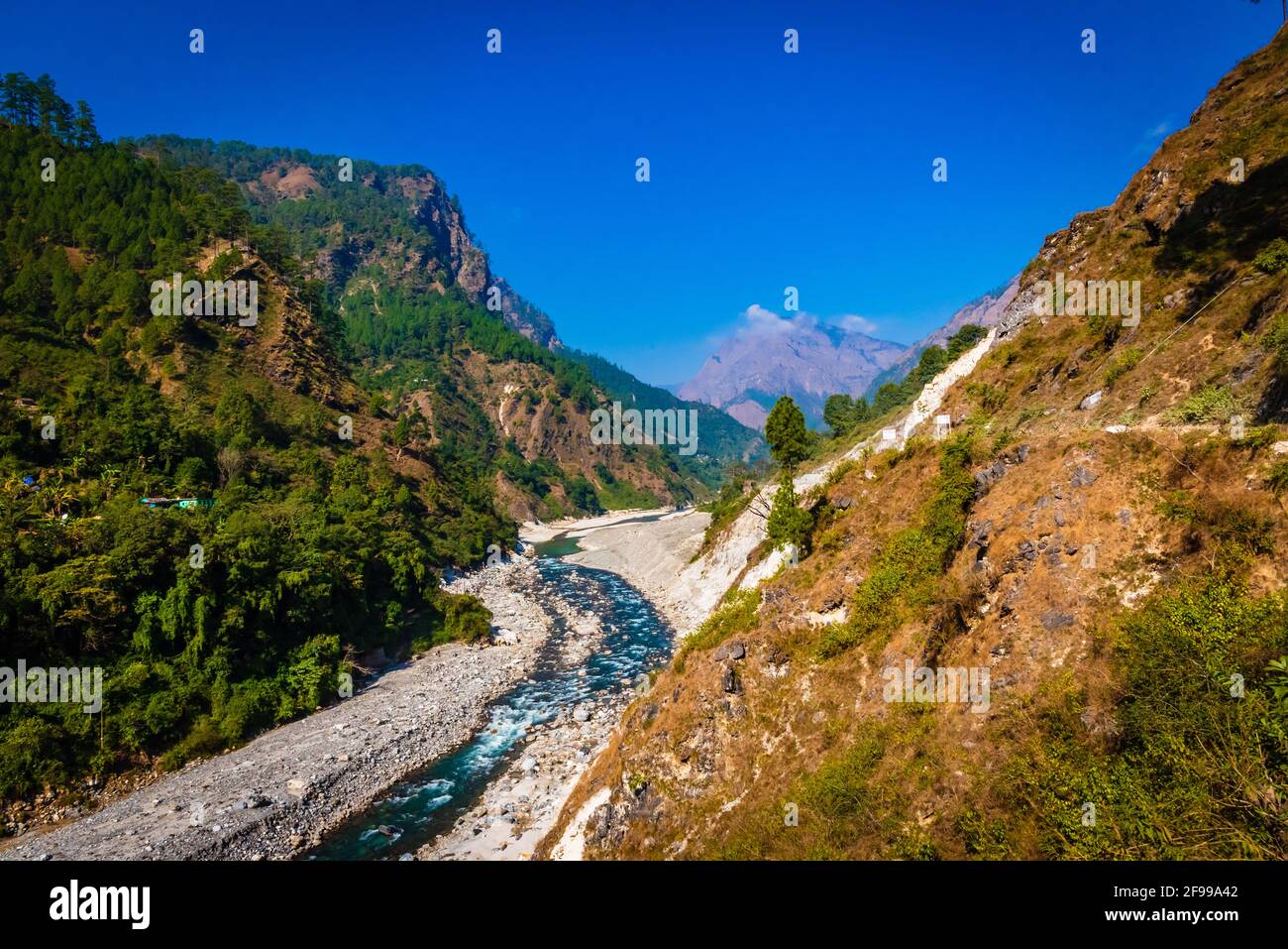 Vista del fiume Ranganga e la valle ai campi sullo sfondo del cielo blu e catene montuose dell'Himalaya, vicino Nainital, Uttarakhand, in Foto Stock