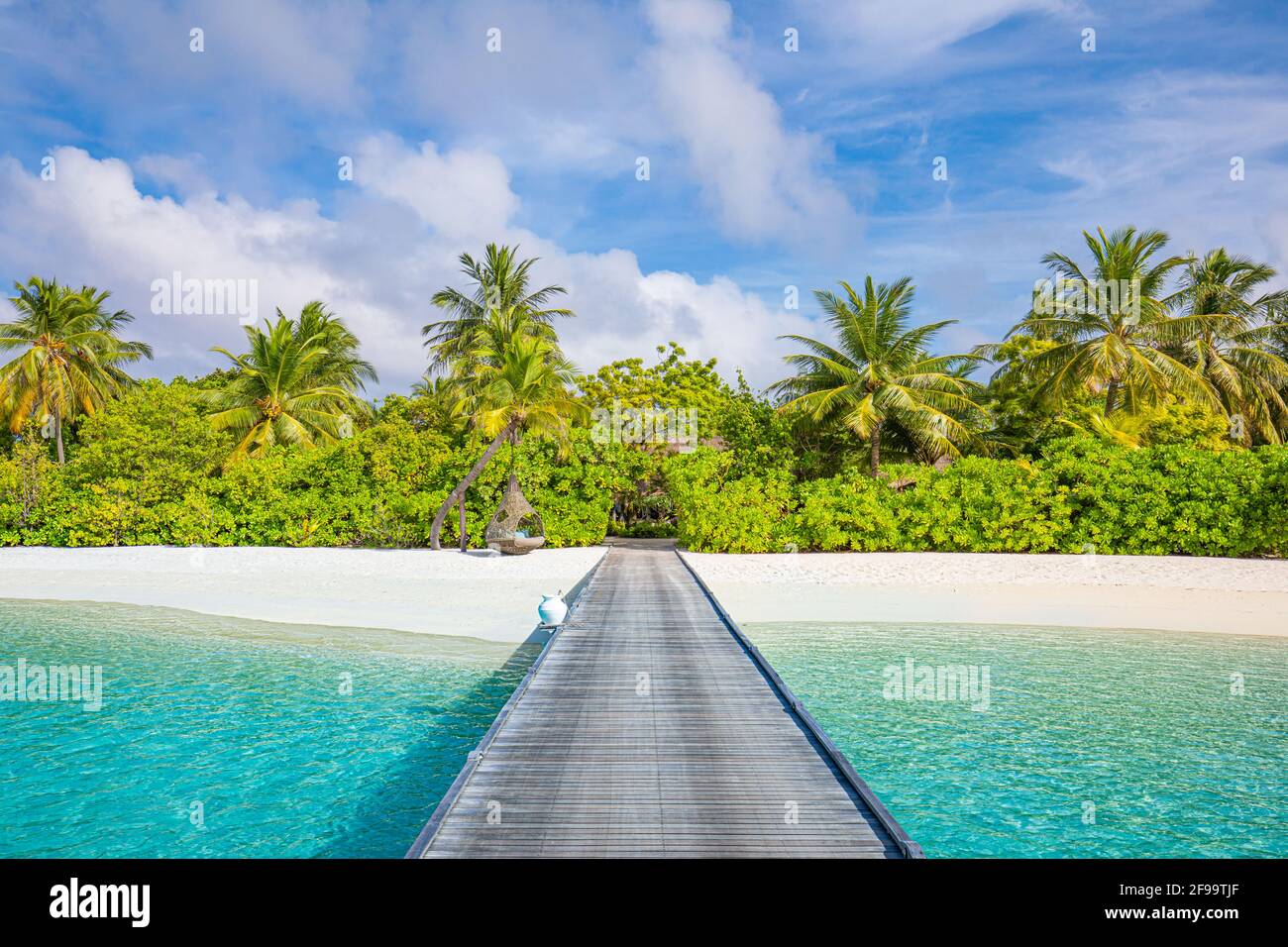 Maldive isola, resort di lusso, molo in legno in paradiso spiaggia. Splendido cielo e nuvole palme sfondo per vacanze estive, in viaggio Foto Stock