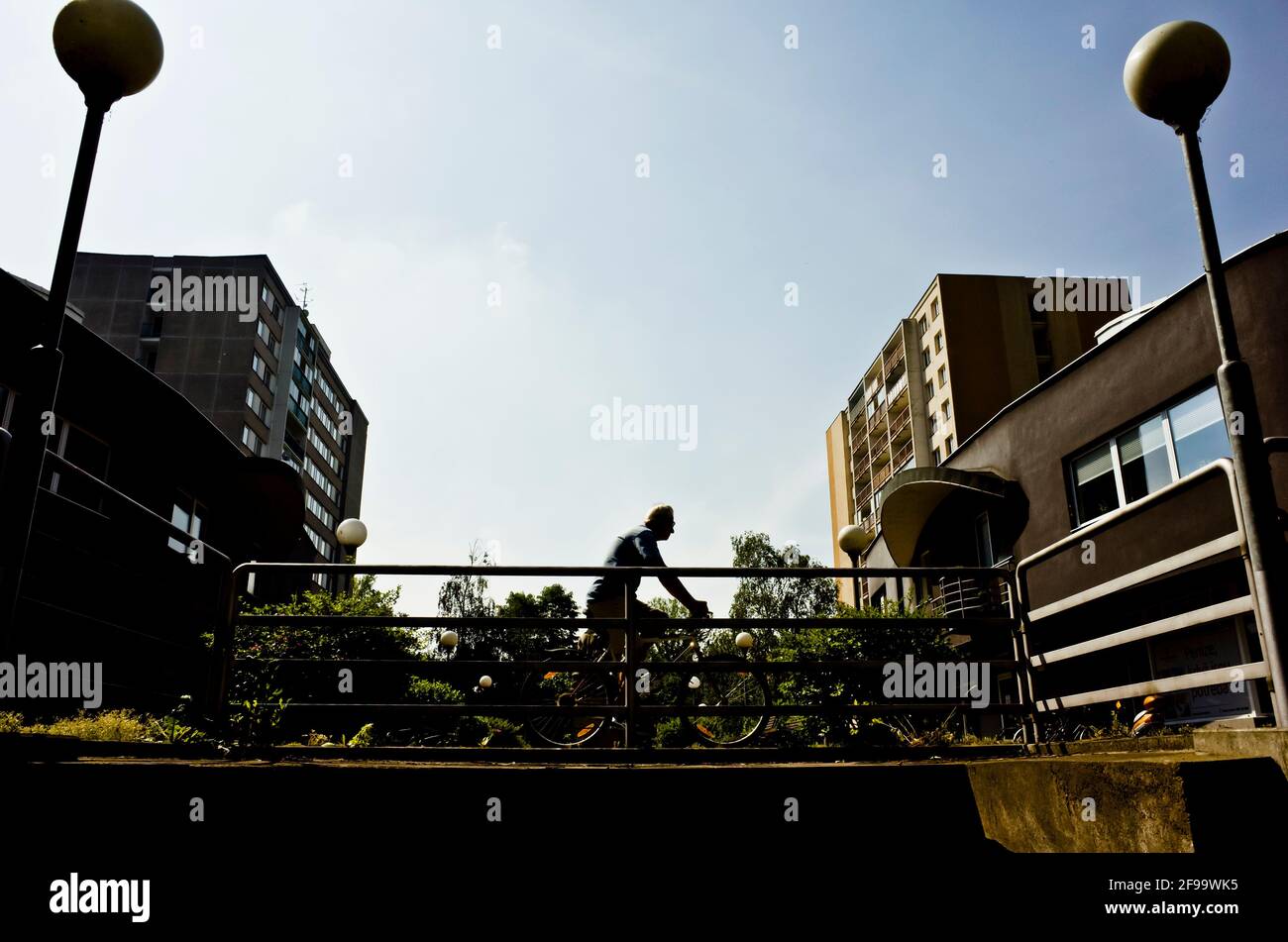 silhouette di un uomo in bicicletta in città Foto Stock