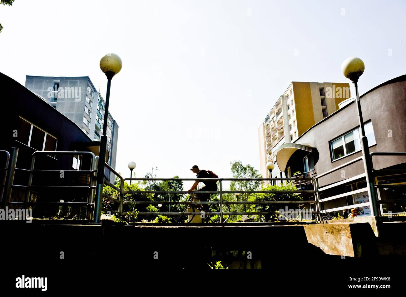 silhouette di un uomo in bicicletta in città Foto Stock