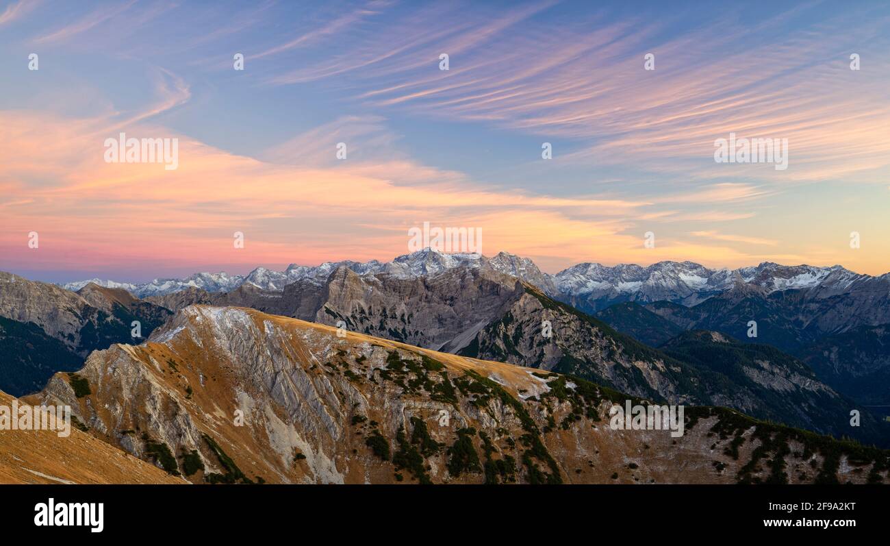Paesaggio montano d'autunno dopo il tramonto sulle Alpi di Ammergau. Sullo sfondo la catena Zugspitze e Mieminger. Baviera, Germania, Europa Foto Stock